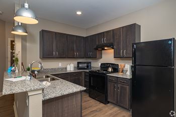 A kitchen with black appliances and granite counter tops
